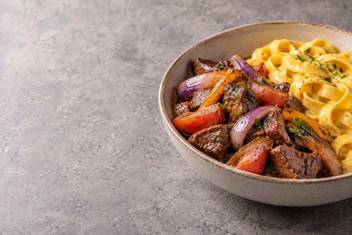 Lomo saltado con fetuccini a la huancaína